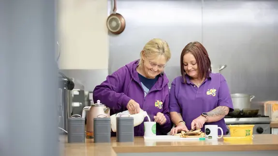 Two Ladies Making Hot Drinks In Canteen