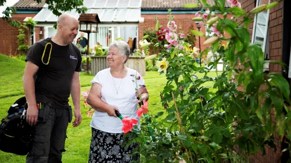 Places Management Employee Chats To Happy Lady In Garden