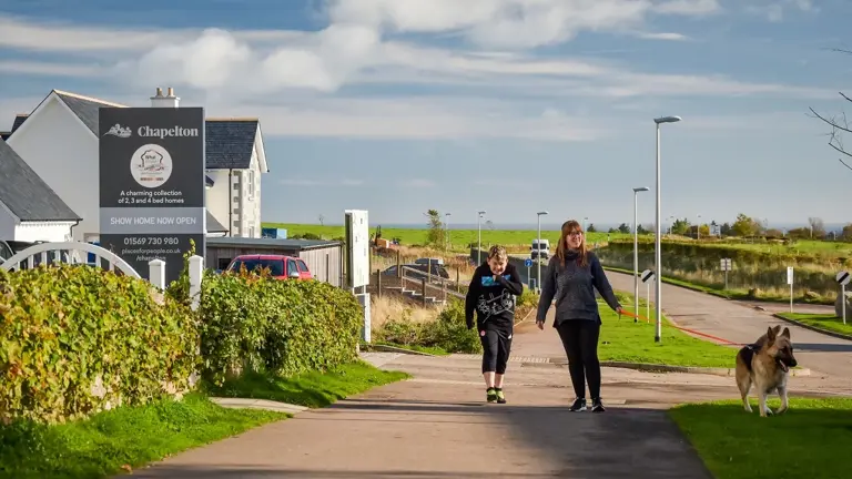 Mother And Son Walking With Dog
